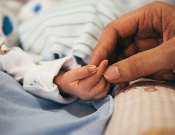 father holding new born hand